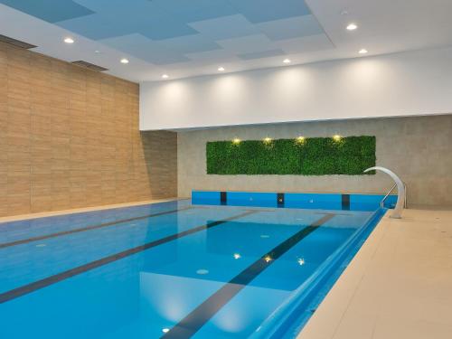 a swimming pool with blue water in a building at Tennis & Country Club Hotel in Giebułtów