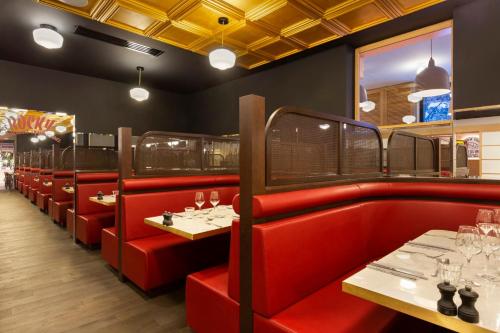 a restaurant with red booths and tables with wine glasses at RockyPop Flaine Hotel & Spa in Flaine