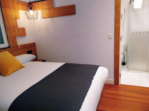 a bedroom with a bed with a black and white blanket at Pensión La Perla in Donostia-San Sebastián