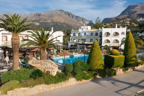 a resort with a swimming pool and palm trees at Alianthos Garden in Plakias