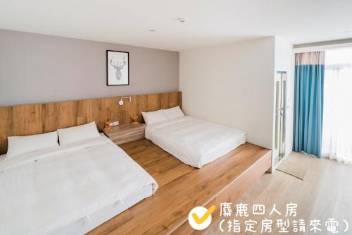 a bedroom with two beds and a window at Pomelo Homestay in Houli