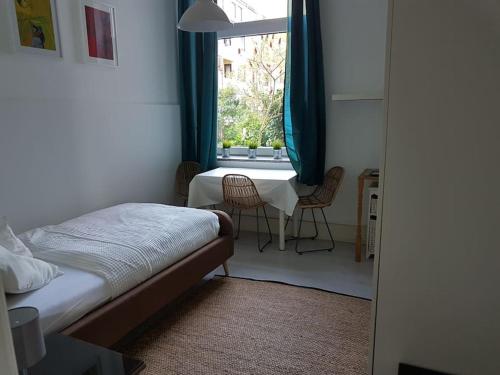 a bedroom with a bed and a window with chairs at Low Budget in Bremen