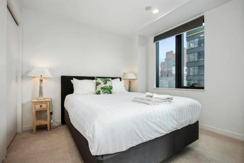 a bedroom with a large bed and a window at Super Central To SkyTower - Fast Wifi - Netflix in Auckland