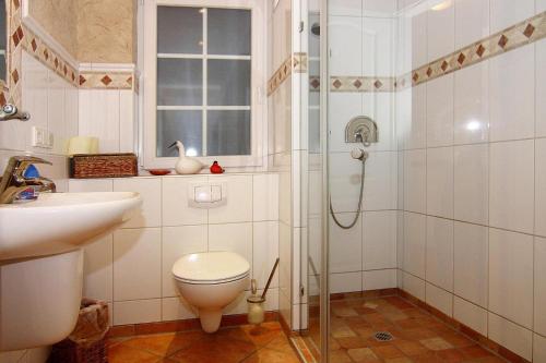 a bathroom with a shower and a toilet and a sink at Semi-detached house, Zingst in Zingst