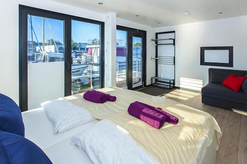 a bedroom with a large bed with purple pillows on it at Haus in Ribnitz Damgarten for 3 Personen in Ribnitz-Damgarten