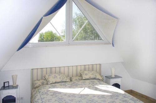 a bedroom with a large window above a bed at Semi-detached house, Zingst in Zingst