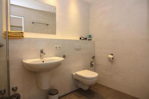a white bathroom with a sink and a toilet at Apartment Villa Nicole, Zingst in Zingst