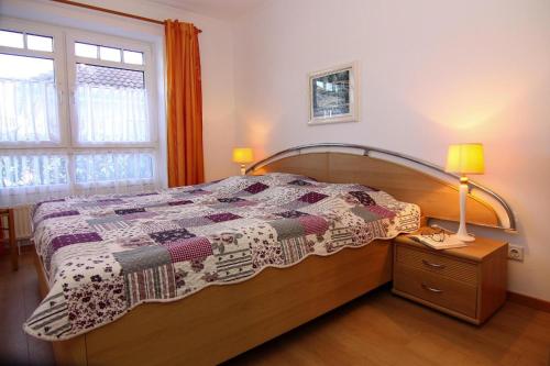 a bedroom with a bed with a quilt on it at Apartment Villa Nicole, Zingst in Zingst
