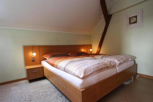 een slaapkamer met een groot bed met een houten hoofdeinde bij Holiday complex Landlust M hlental in Oberwürschnitz