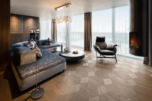 a living room with a couch and a chair at Wellness- & Sporthotel Jagdhof in Röhrnbach