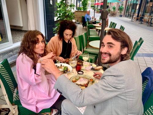 a group of people sitting at a table eating food at Belle de Nuit in Ostend