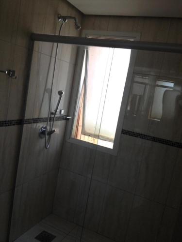a bathroom with a shower with a window at Residence Plaza Flat in Ribeirão Preto