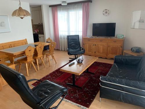 ein Wohnzimmer mit einem Sofa, einem Tisch und Stühlen in der Unterkunft Casa Surselva Whg Bilger in Savognin