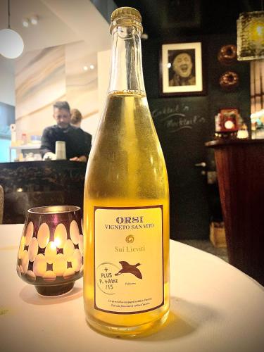 a bottle of oil on a table with a glass at Belle de Nuit in Ostend