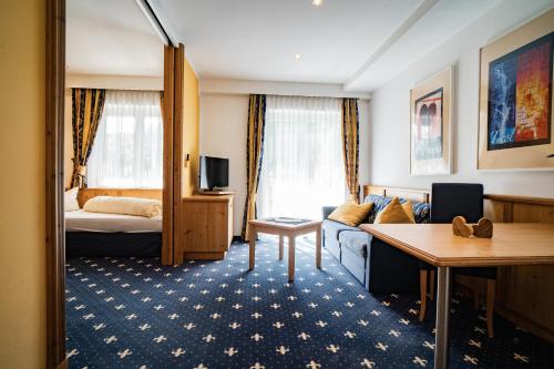 a hotel room with a couch and a bed at Aktiv Hotel Zur Rose am Brenner in Steinach am Brenner