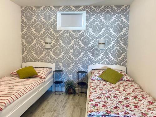 een slaapkamer met 2 bedden en een muur bij Villa Maslina in Sutivan