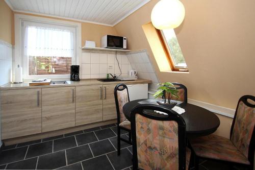 a small kitchen with a table and a counter at Ferienhaus Storchennest 2, Falkensee in Falkensee