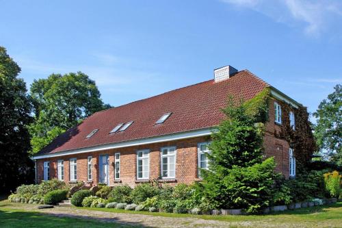 a large brick house with a red roof at Ferienwohnung im Gutshaus Schulenbrook in Metelsdorf