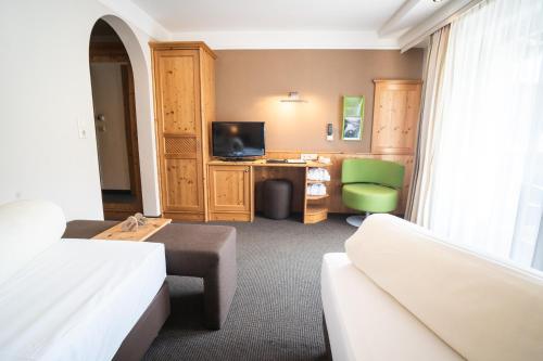 a hotel room with a bed and a desk at Aktiv Hotel Zur Rose am Brenner in Steinach am Brenner