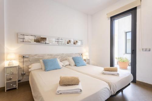 1 dormitorio blanco con 1 cama grande con almohadas azules en Villa Angela Family Suite, en Inca