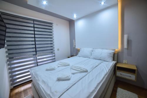 a bedroom with a large white bed with a window at Balkan Hill Zlatibor in Zlatibor