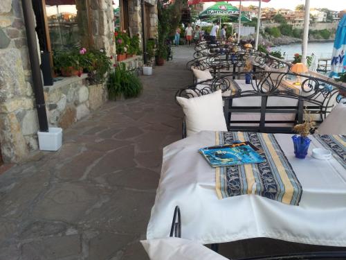una fila de mesas con manteles blancos en Guest House Rusalka, en Sozopol