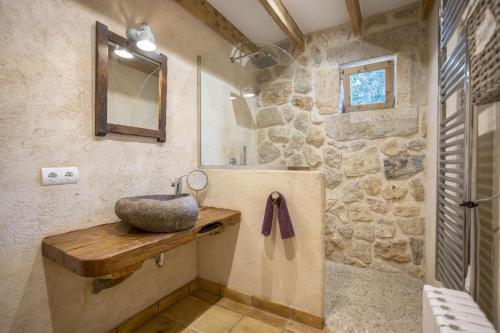 a stone bathroom with a sink and a mirror at Villa Coric in Inca