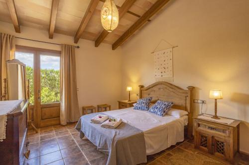 ein Schlafzimmer mit einem Bett und einem großen Fenster in der Unterkunft Finca Sa Tanqueta Rústica in Inca