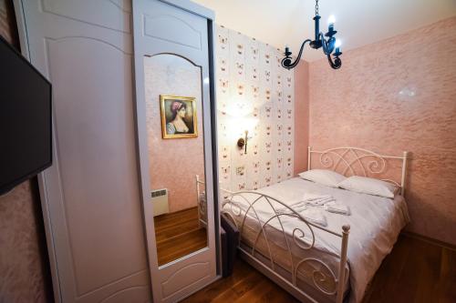 a small bedroom with a bed and a mirror at Balkan Hill Zlatibor in Zlatibor