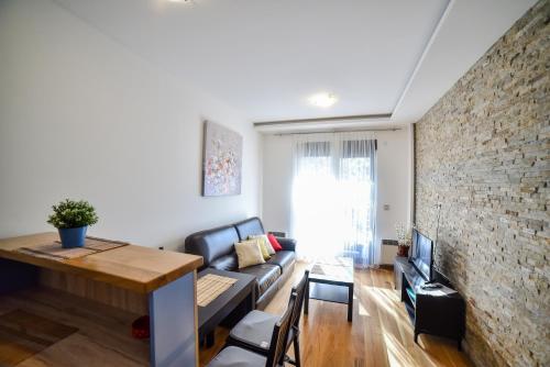 a living room with a couch and a brick wall at Balkan Hill Zlatibor in Zlatibor