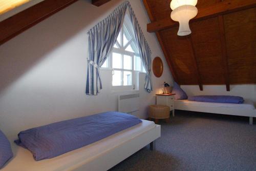 1 dormitorio con cama y ventana en Holiday home Fischer Sien Huus, Steinhude, en Steinhude