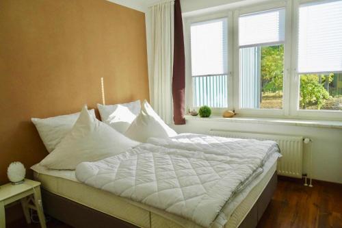 - une chambre avec un lit doté de draps blancs et de fenêtres dans l'établissement Apartment, Zinnowitz, à Zinnowitz