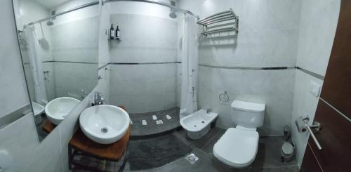 een witte badkamer met een wastafel en een toilet bij Departamento Mara Bariloche in Bariloche