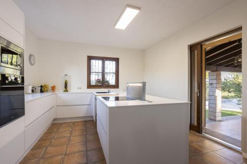 a kitchen with white cabinets and a counter top at Villa Es Triquet Family in Binissalem
