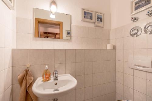 a white bathroom with a sink and a mirror at Alpendomizil 3 in Bolsterlang