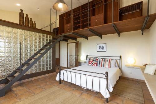 a bedroom with a large bed and a staircase at Villa Es Triquet Family in Binissalem