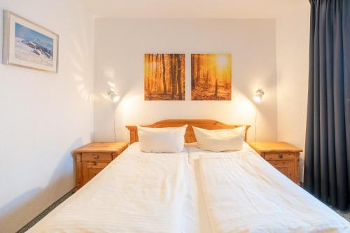 a bedroom with a white bed with two pillows at Alpendomizil 3 in Bolsterlang