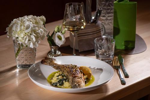 a plate of food with a fish on a table at MONDI Appartements am Grundlsee in Grundlsee