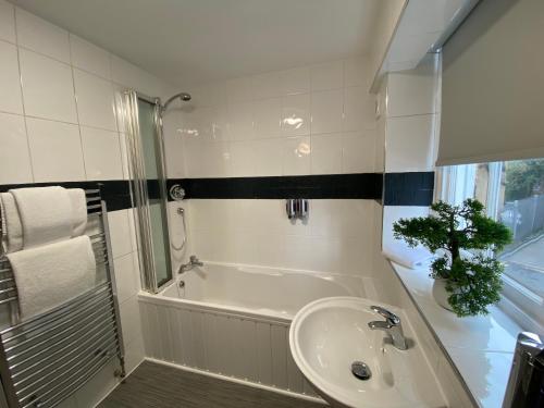 a bathroom with a bath tub and a sink at Crows Hotel in Lancaster