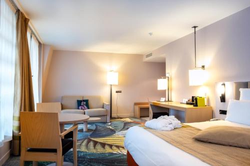 a hotel room with a bed and a desk at Mercure Amiens Cathédrale in Amiens