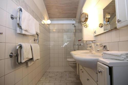 a white bathroom with a sink and a toilet at Ferienhaus Am Wung, Husum in Husum