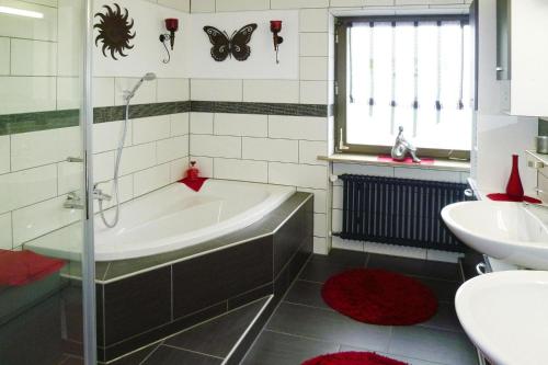 ein Badezimmer mit einer Badewanne und einem Waschbecken in der Unterkunft Apartment, Oberdorf near Langenargen in Oberdorf