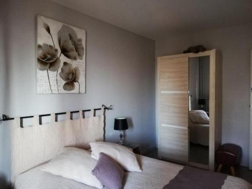een slaapkamer met een bed met bloemen aan de muur bij L'Orée du Parc à Belfort in Belfort