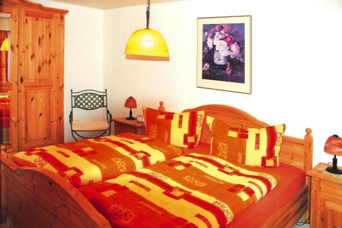 1 dormitorio con 2 camas y mantas de color naranja y amarillo en Holiday house "Rennsteig" , Suhl, en Suhl