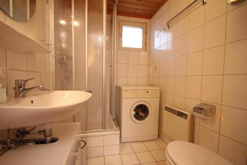 ein Badezimmer mit einem Waschbecken und einer Waschmaschine in der Unterkunft Ferienhaus am Useriner See, Userin in Userin