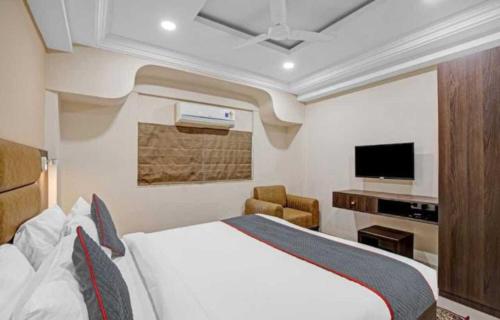 a hotel room with a bed and a tv at Alba Premier, Ahmedabad in Ahmedabad