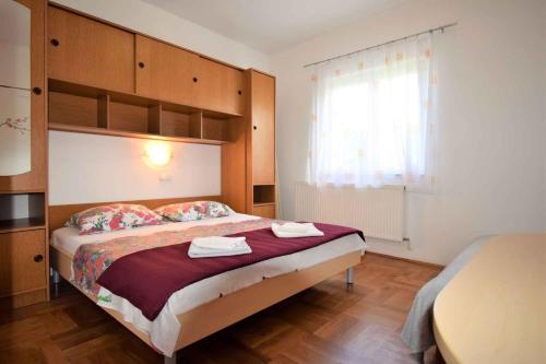 una camera da letto con un letto e due asciugamani di Apartment in Lopar a Lopar