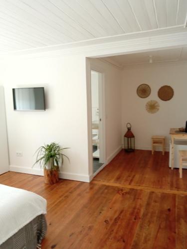 a bedroom with white walls and a wooden floor at Casa da Umbria in Odemira