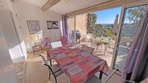 une salle à manger avec une table et des chaises et un balcon dans l'établissement Les Bastides de Pan Cuet, à Sainte-Maxime