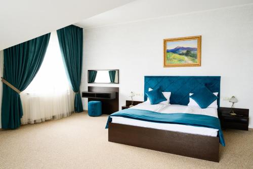 a bedroom with a bed with a blue head board at Dolce Vita in Bukovel